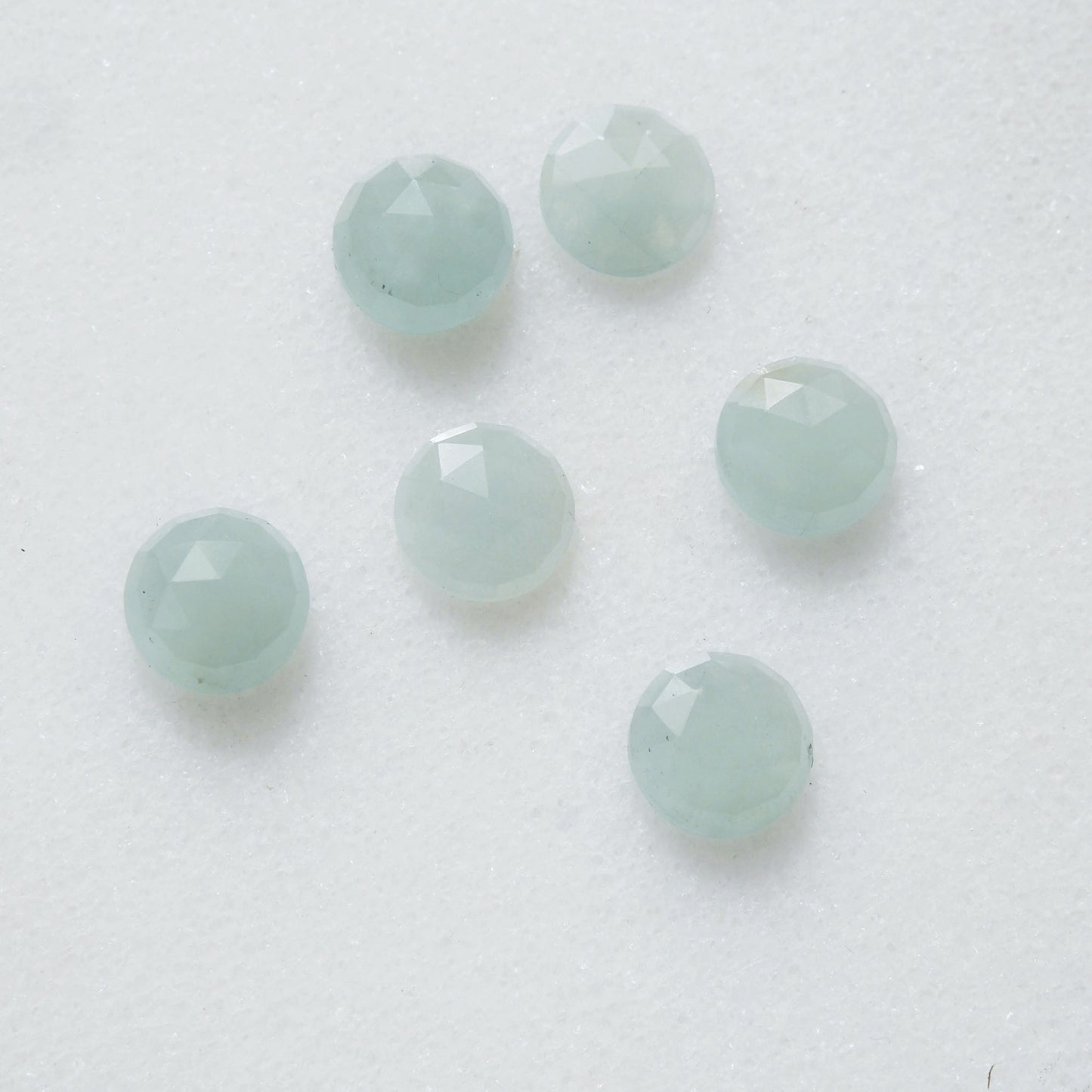 a group of 6 faceted blue/green aquamarine gemstone cabochons