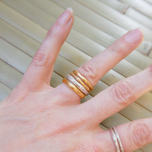 Hand wearing stacked bamboo style rings, in three thicknesses in Sterling Silver & Gold Vermeil