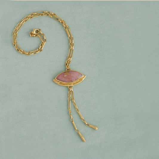 Gold Lariat style chain necklace, with a wide Marquise shaped Pink Peruvian opal gemstone pendant, framed by a half halo of Gold bamboo. On light duck egg velvet background.
