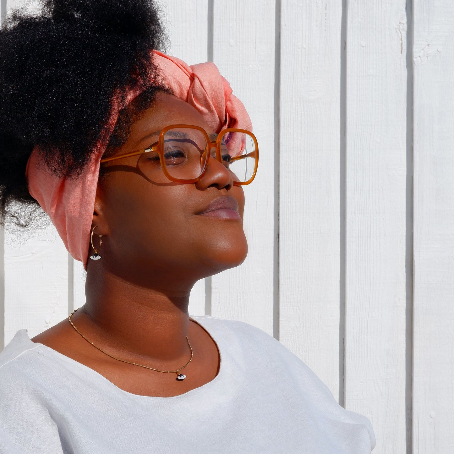 small gold hoop earrings with dainty black spiky palm design, and matching pendant,  on mother of pearl, in oyster shell