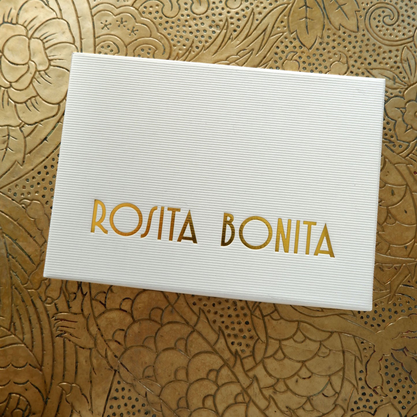 Large White finely ribbed cardboard jewellery box, with ROSITA BONITA logo branding in Gold foil, on gold patterned background
