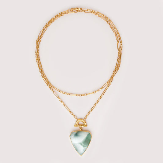 Pendant with large shield shaped green hemimorphite gemstone hanging from Gold Bamboo Arch, a long doubled gold chain. light grey Background