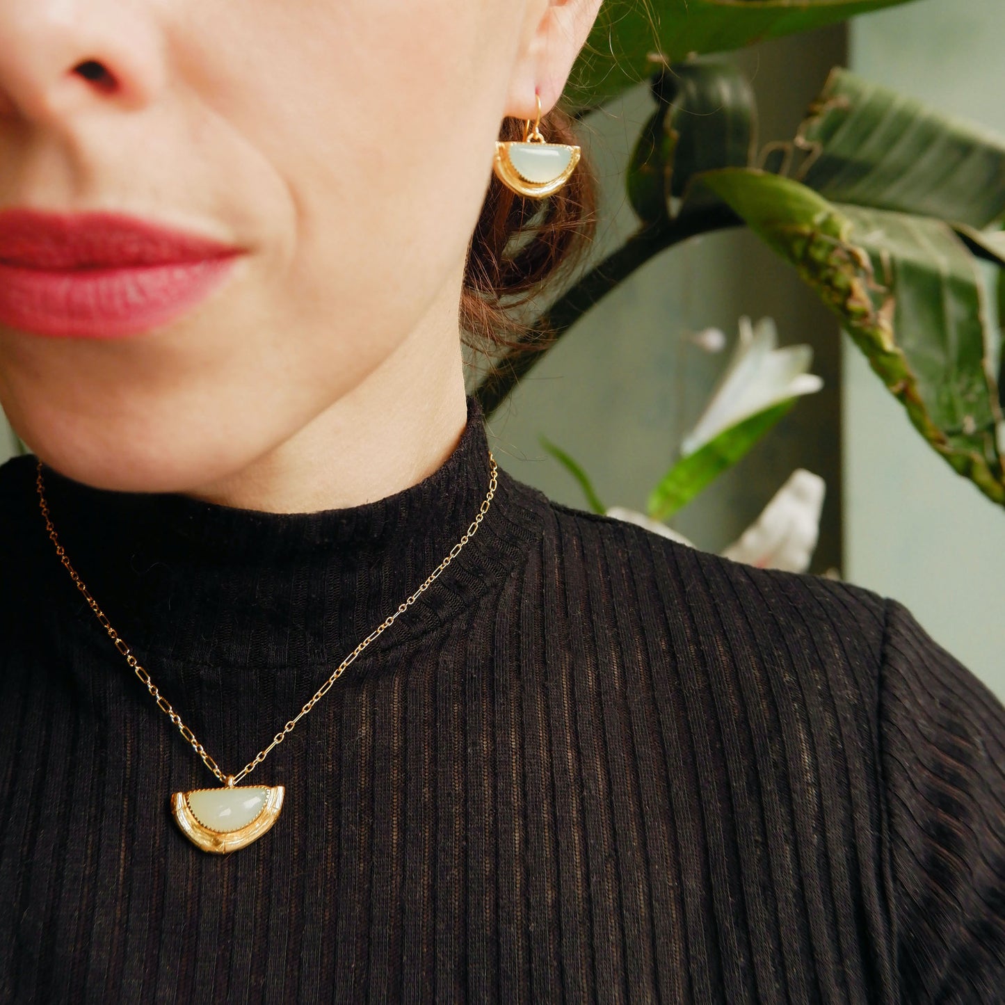 Earrings featuring half moon shaped semi precious aqua blue chalcedony gemstones, cupped by solid silver bamboo hammock, plated in gold vermeil, with simple wire ear hooks. On model, with matching pendant.