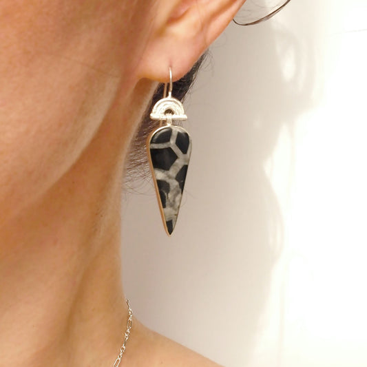 drop earring in sterling silver, featuring a triple arch of bamboo on a hook fitting, hung with a long pear/teardrop shaped black septarian gemstone pendant.