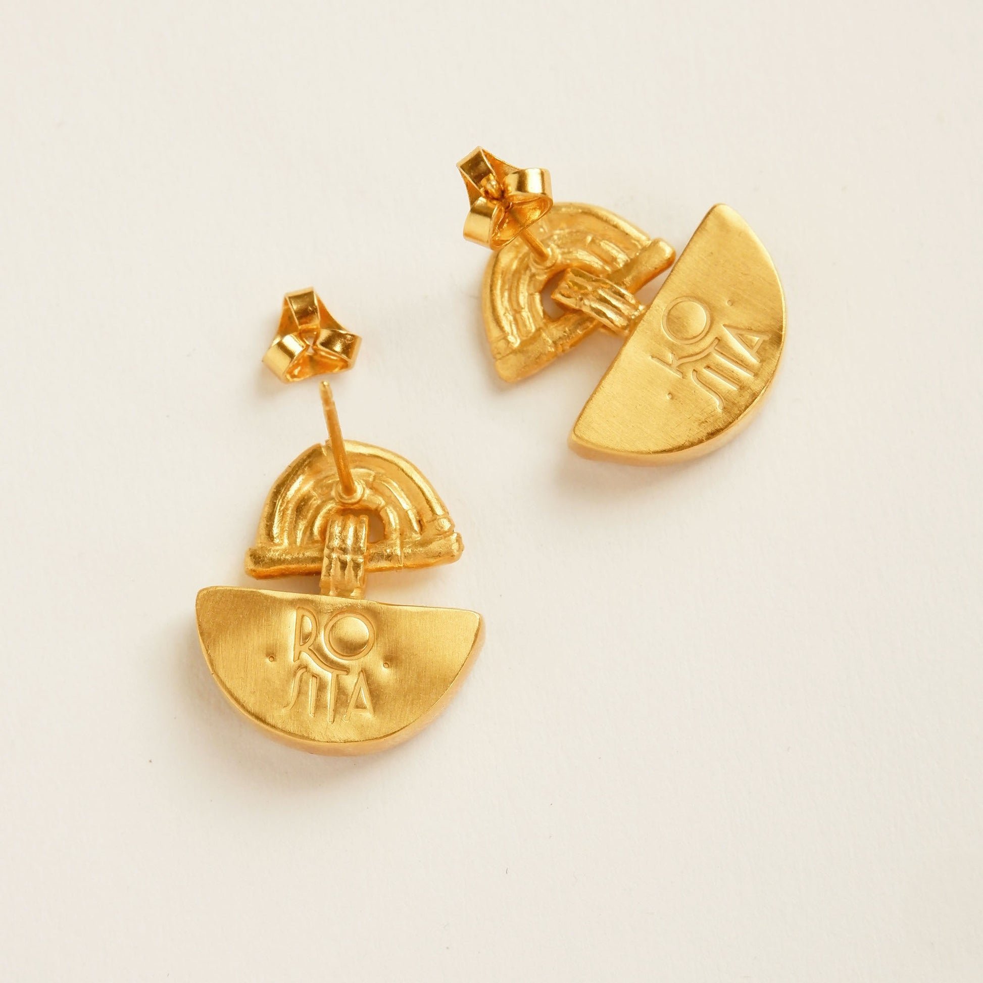 small stud earrings in gold vermeil, hung with a half moon shaped pendants. Shown from the back with Rosita Logo embossed.