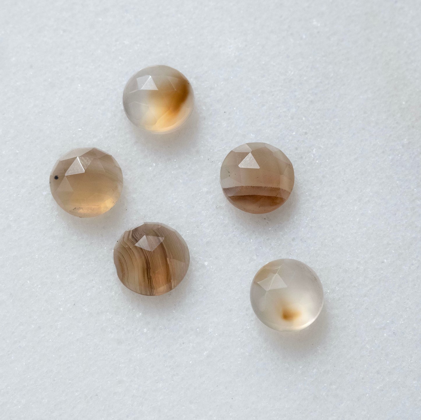 a group of 5 faceted golden brown translucent Montana agate gemstone cabochons, each with unique markings.