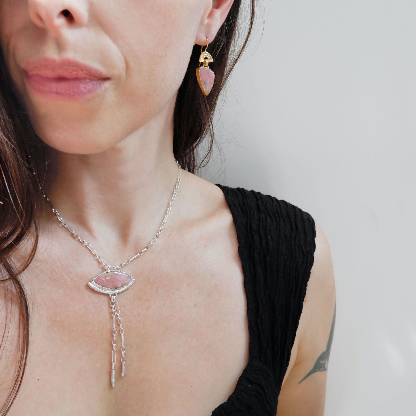 drop earrings in gold vermeil, featuring triple arches of bamboo on hooks, hung with pear/teardrop shaped pink opal gemstone pendants, shown on model
