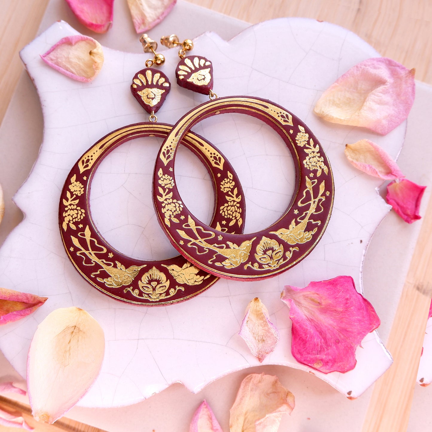 large hoops earring printed with birds & flowers in gold on  ox blood leather