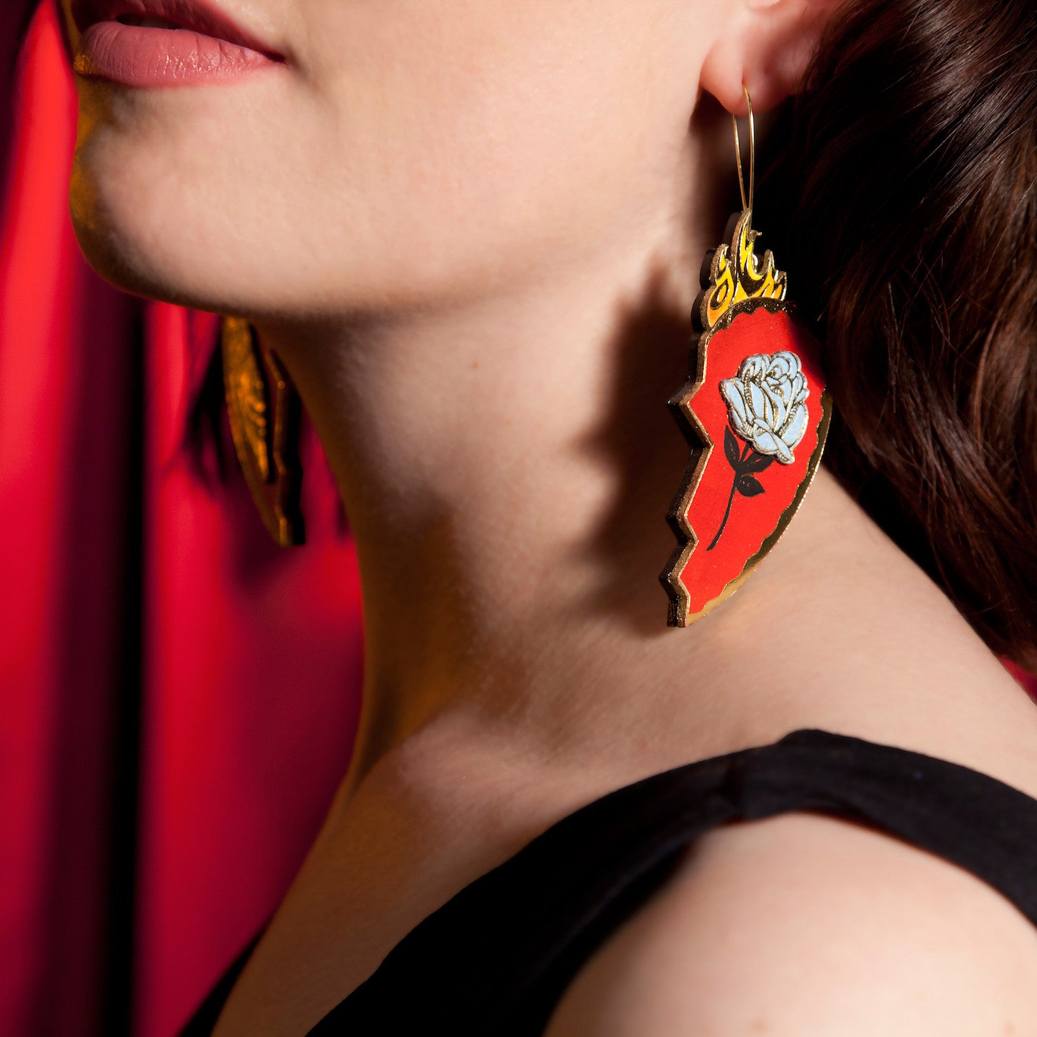 red leather broken heart pendants & earrings, with golden owls, flames & blue roses on model, close crop