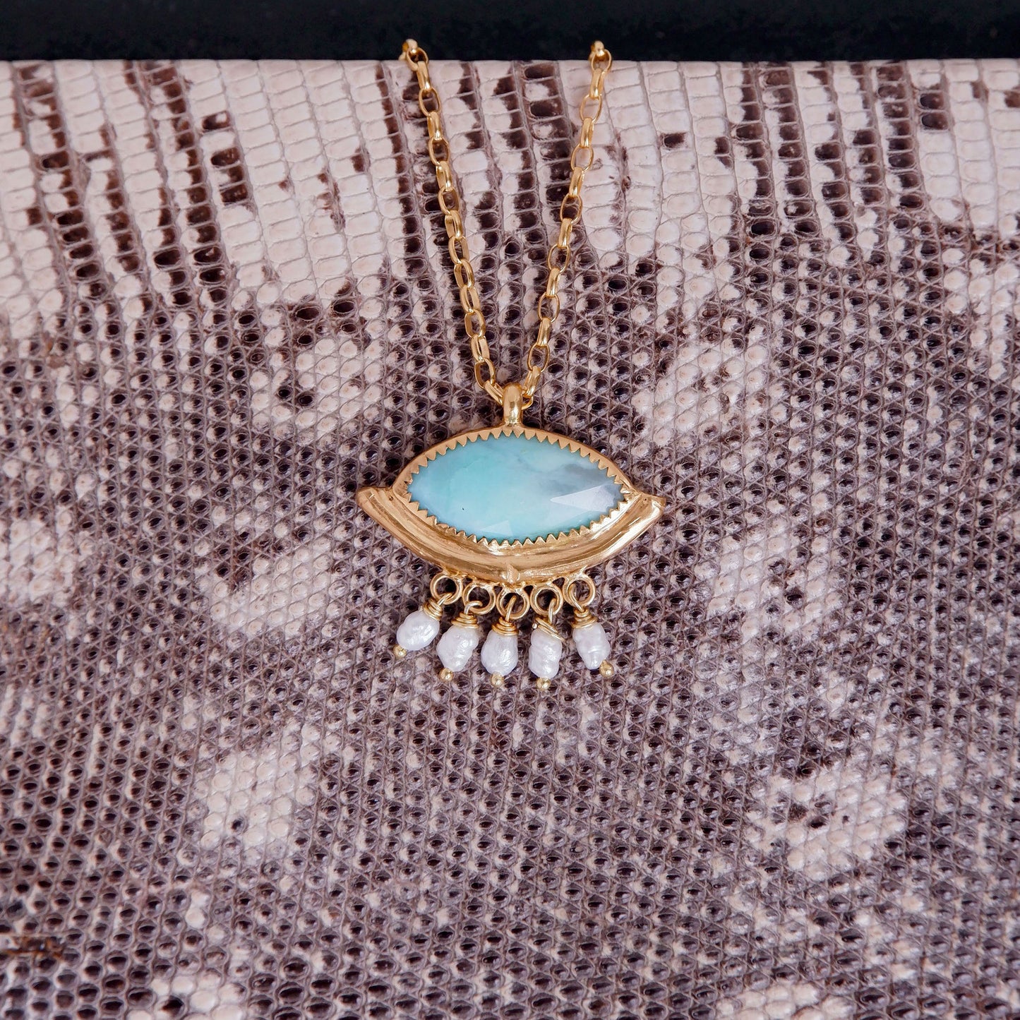 Green peruvian Opal "eye" pendant. Bamboo "hammock" style pendant, with faceted marquise cut gemstone, in gold vermeil, with a fringe of freshwater pearls, on gold chain. Snakeskin background