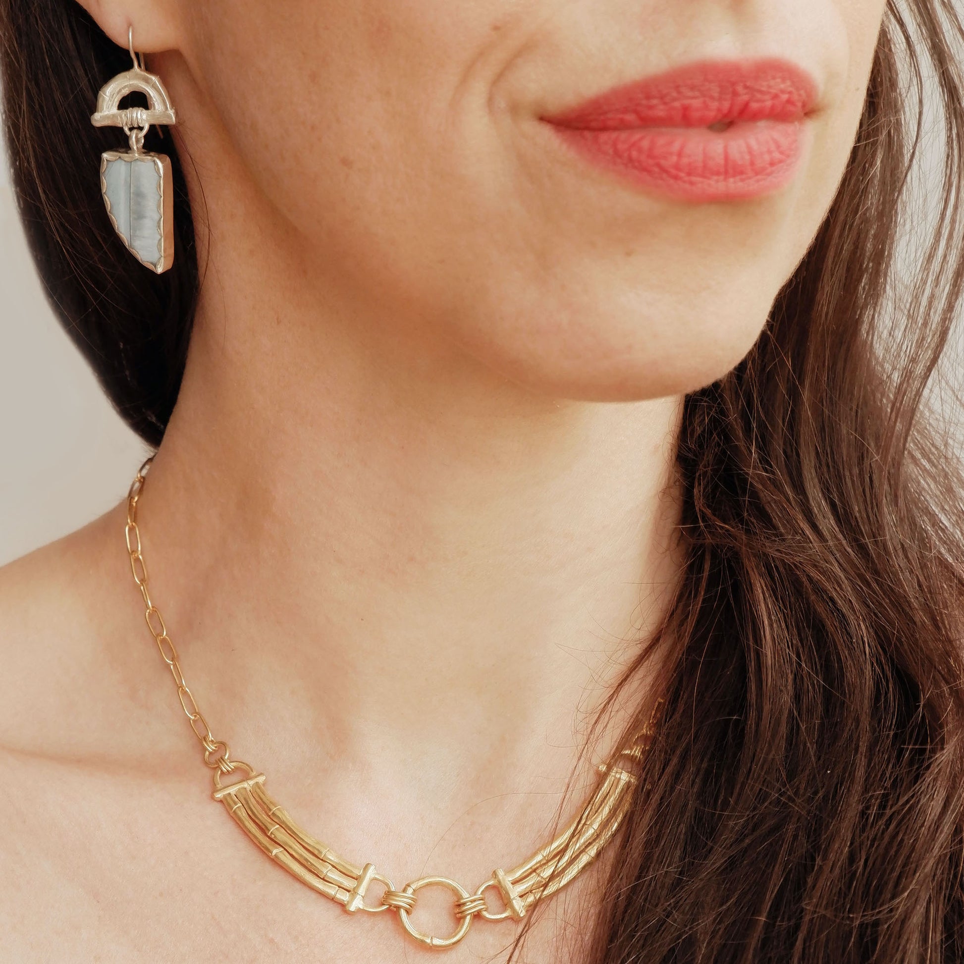 Sterling Silver hook earrings featuring bamboo sunrise arch design, with pointed gemstone drop pendants in light blue opal, shown on model
