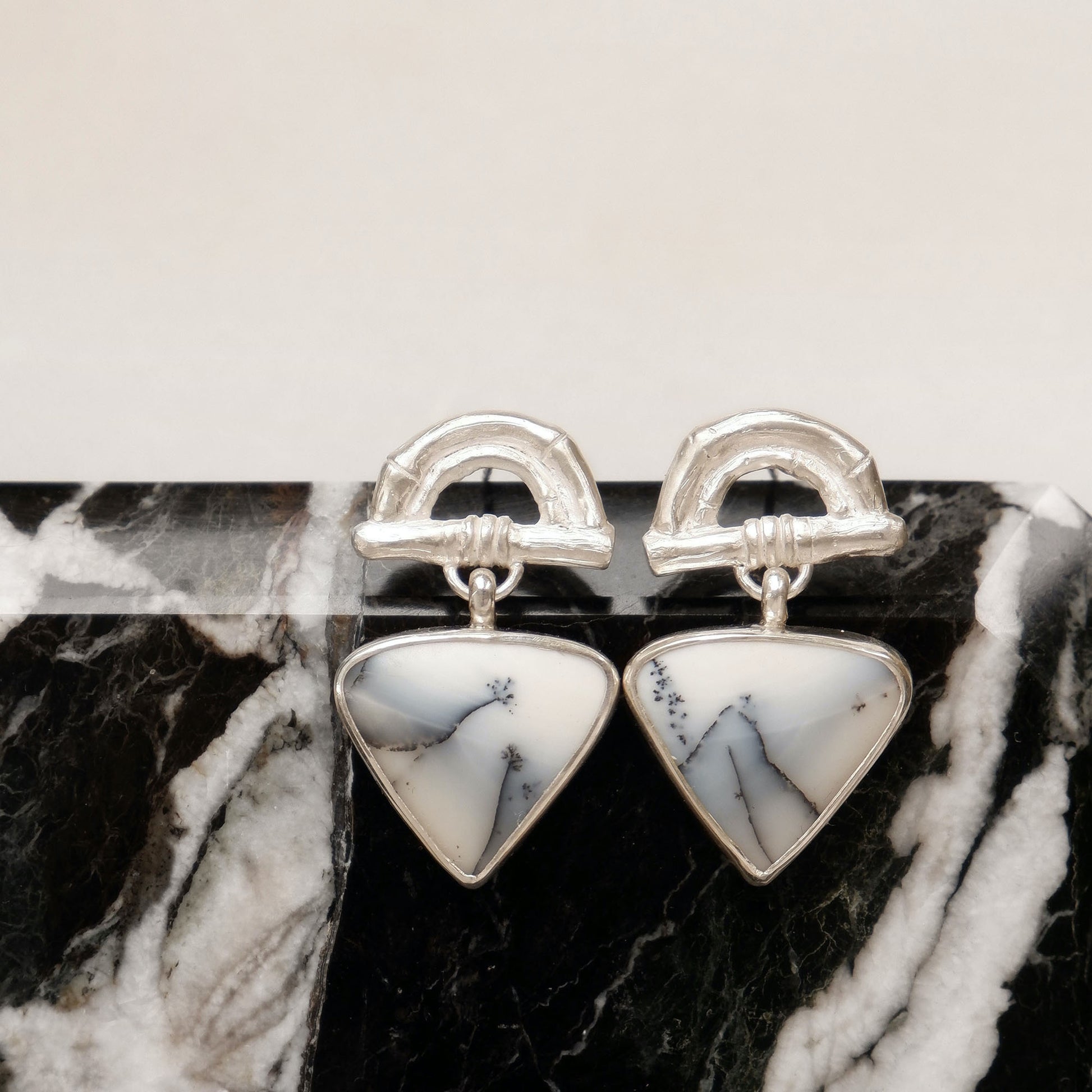Sterling Silver stud earrings featuring bamboo sunrise arch design, with gemstone drop pendants in white & grey Dendrite Opal