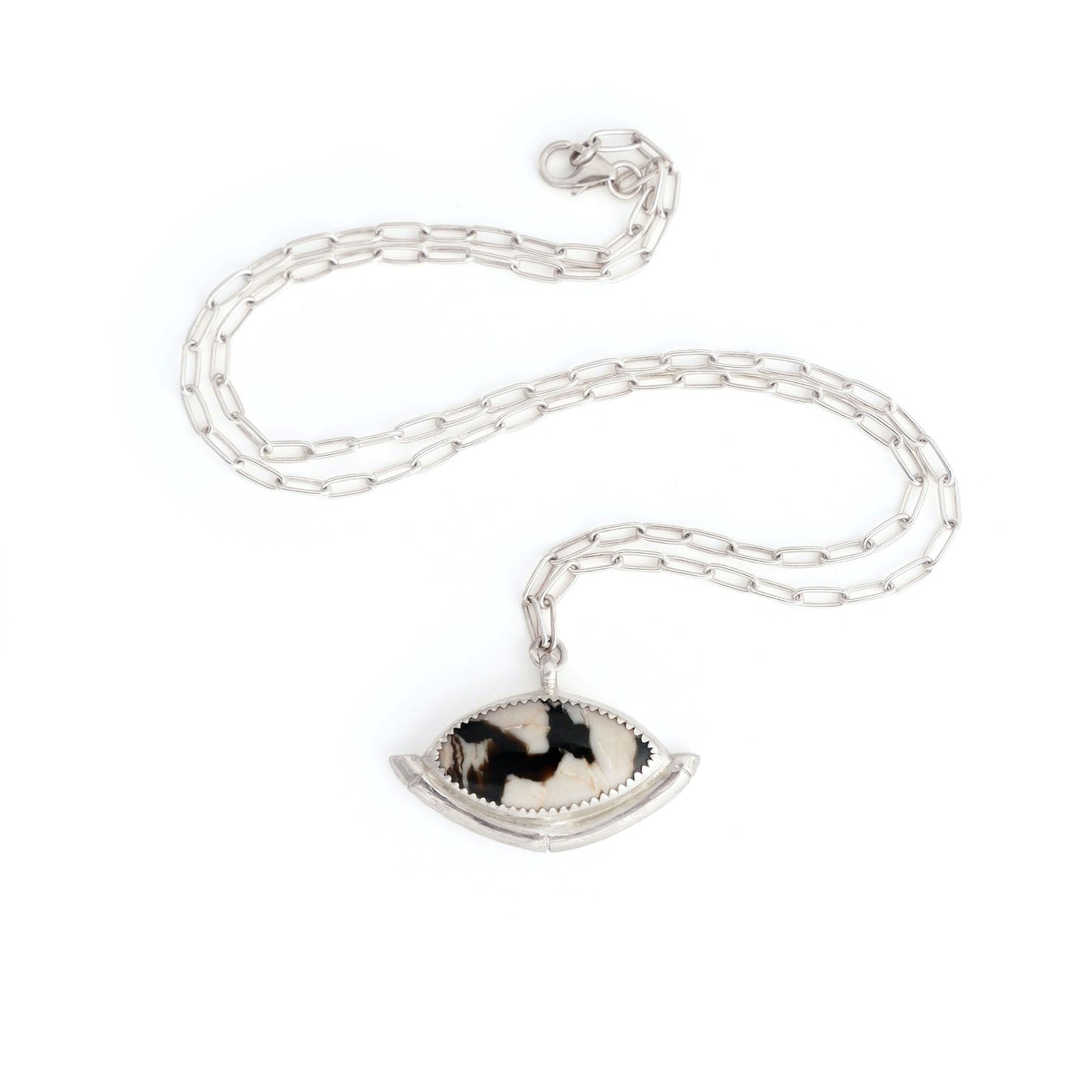 Sterling Silver gemstone Pendant on short paperclip style chain. The pendant features a marquise-cut peanut Wood Cabochon with a striking zigzag pattern in black & white, a serrated sterling silver bezel, and a bamboo style halo mount, cupping the stone.