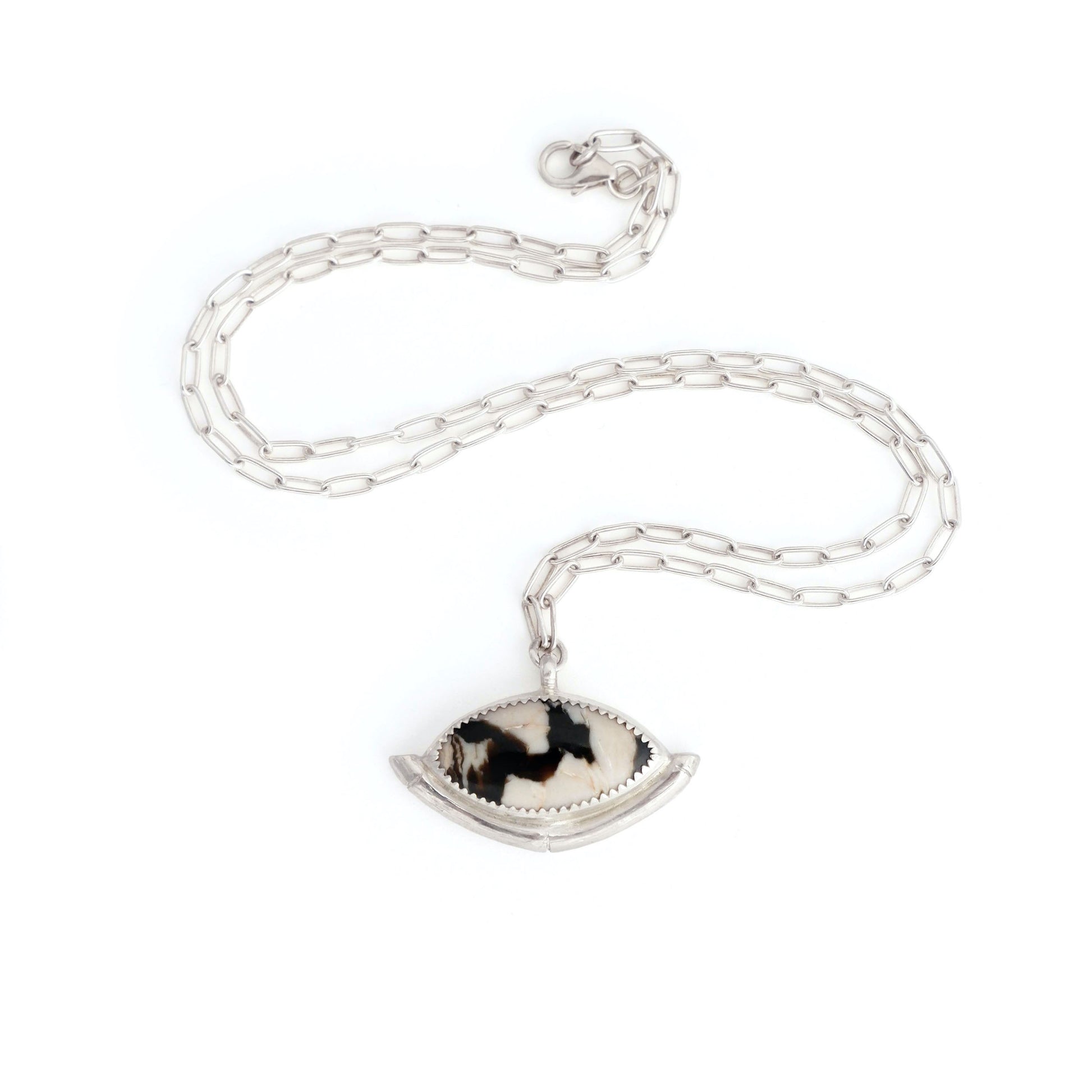 Sterling Silver gemstone Pendant on short paperclip style chain. The pendant features a marquise-cut peanut Wood Cabochon with a striking zigzag pattern in black & white, a serrated sterling silver bezel, and a bamboo style halo mount, cupping the stone.