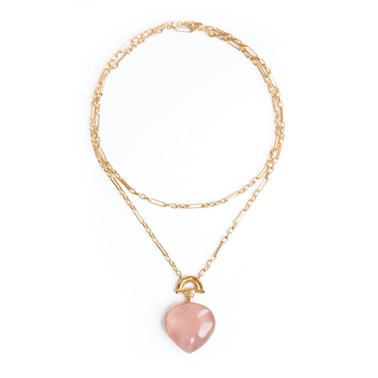 Gold double chain necklace with a rose pink quartz heart-shaped pendant with golden bamboo arch detail, on a white background