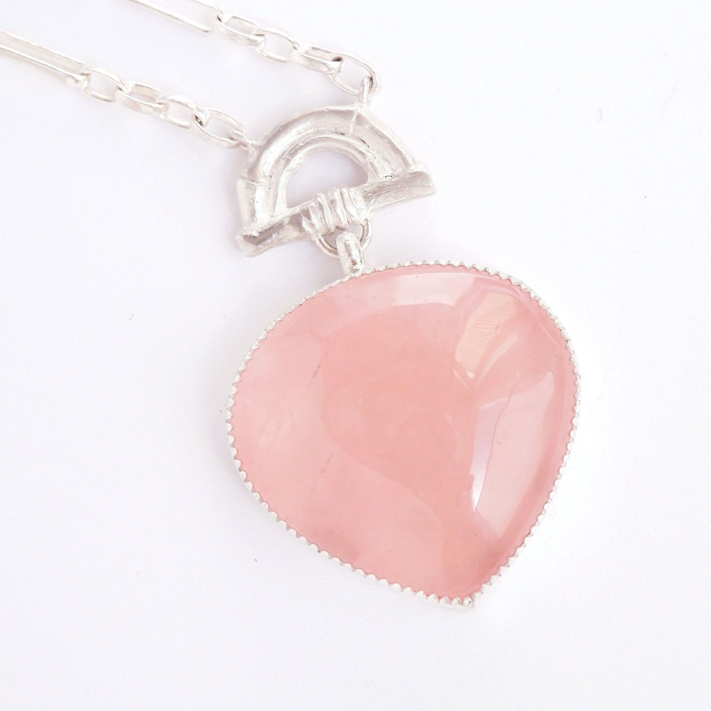 rose pink quartz heart-shaped pendant with sterling silvern bamboo arch detail, on a white background