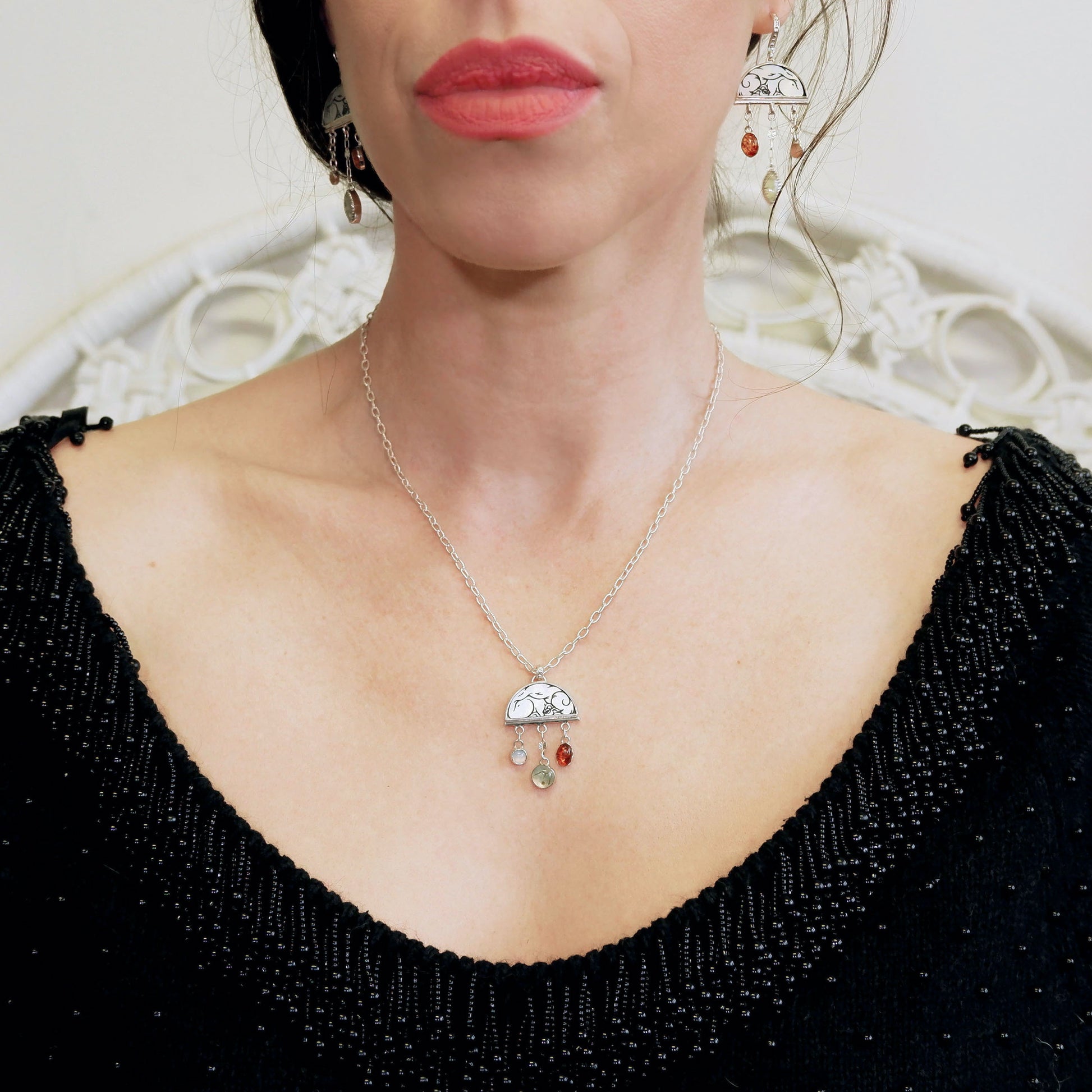 sterling silver half moon pendant necklace on chain, set with mother of pearl, engraved with squirrel illustration, and gemstone drops. Photographed on model, with matching earrings