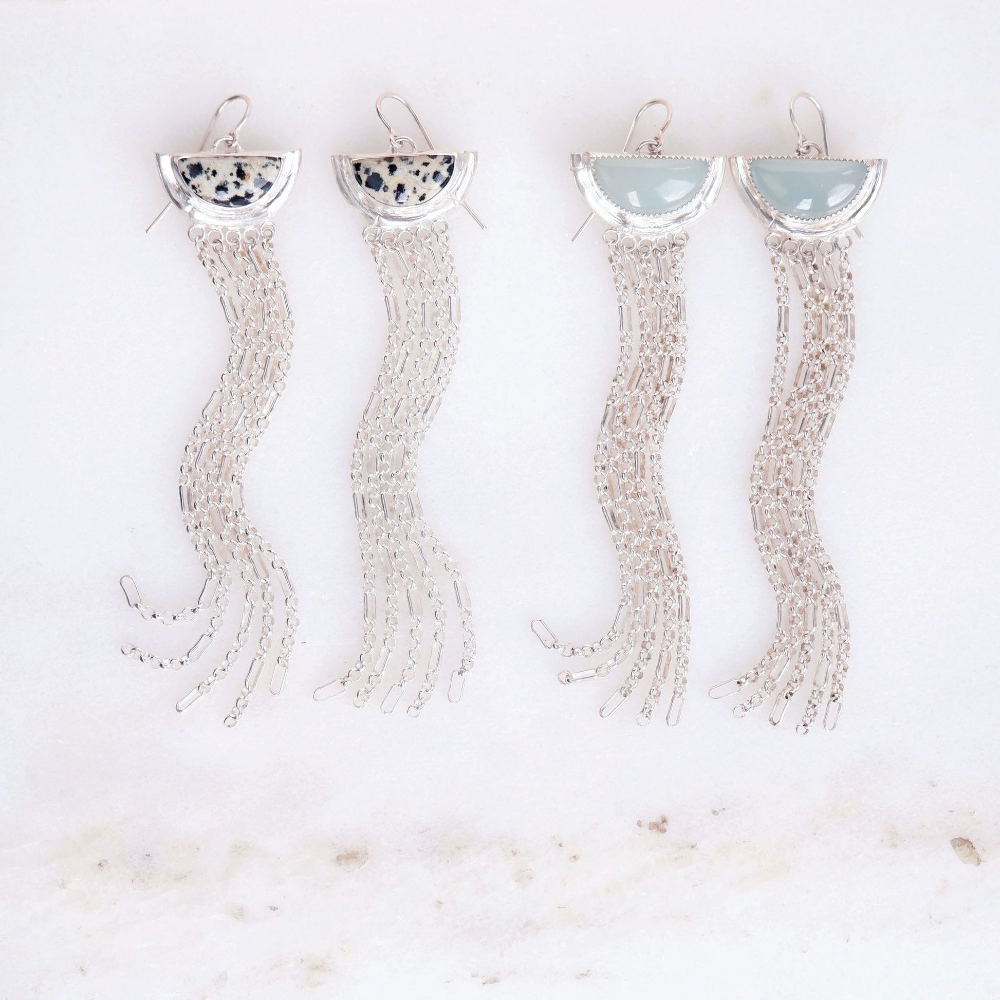 two pairs of sterling silver  tassel earrings with half moon shaped semi precious aqua blue chalcedony  and speckled dalmatian jasper gemstones,  cupped by solid silver bamboo hammock, with simple silver wire hooks.