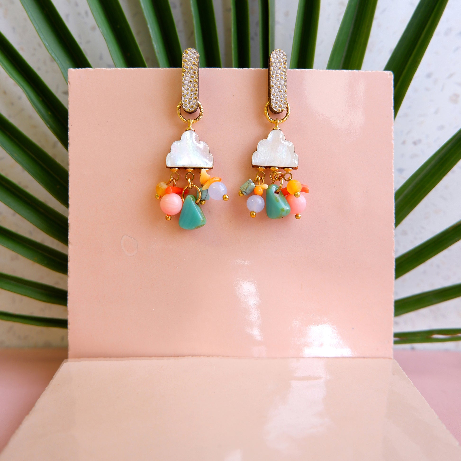 lacquered mother of pear charm drop earrings with rainbow mixed gemstone & glass beads, and sparkly leather studs, lifestyle still life