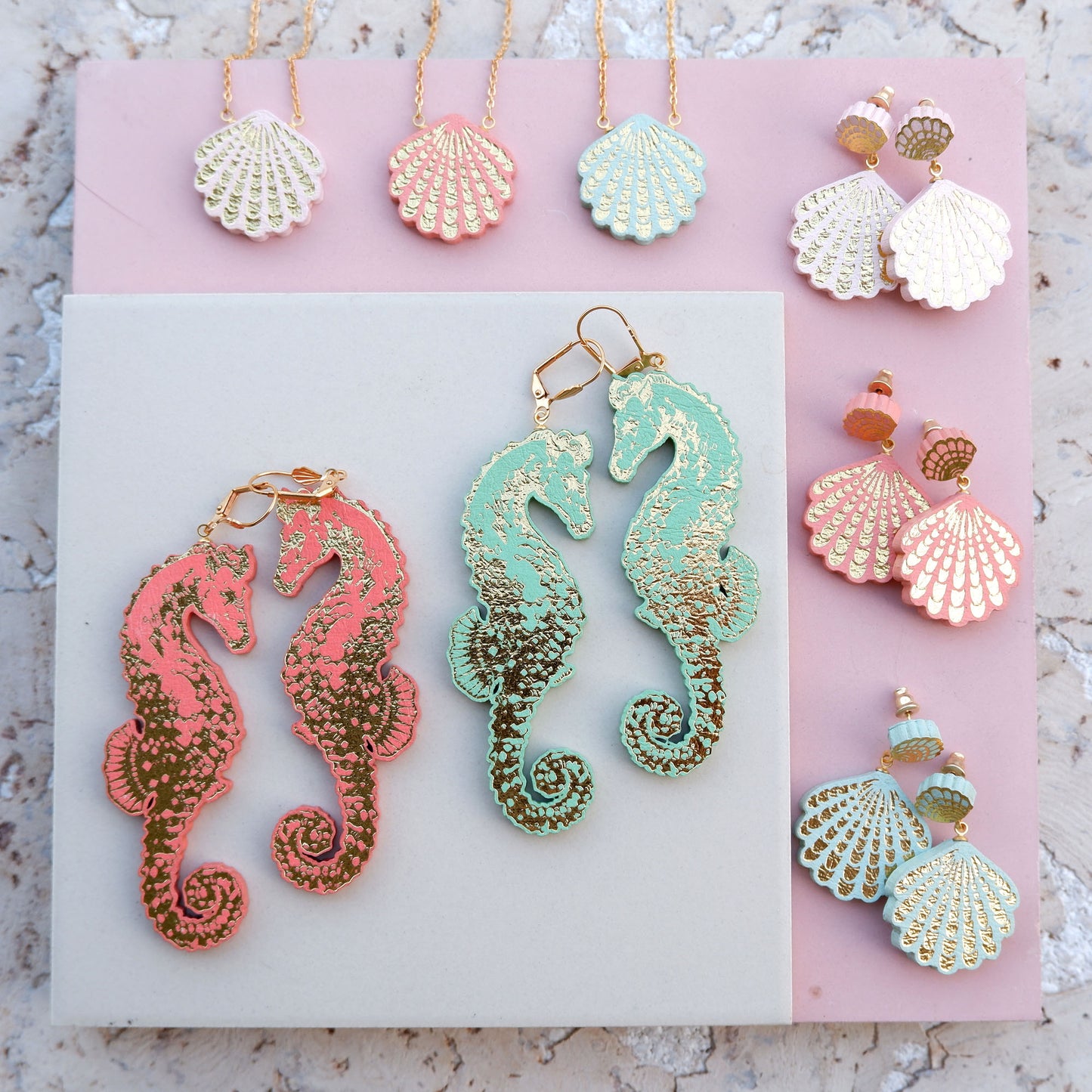 selection of plant based meramid inspired  jewellery. seahorse earrings, sea shell earrings & pendant., all in pastel colours