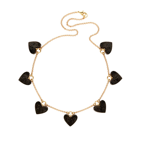 Charm necklace, featuring 7 small  Black Leather Heart pendant; embossed with a  rose & rays design, on fine gold-plated belcher chain.