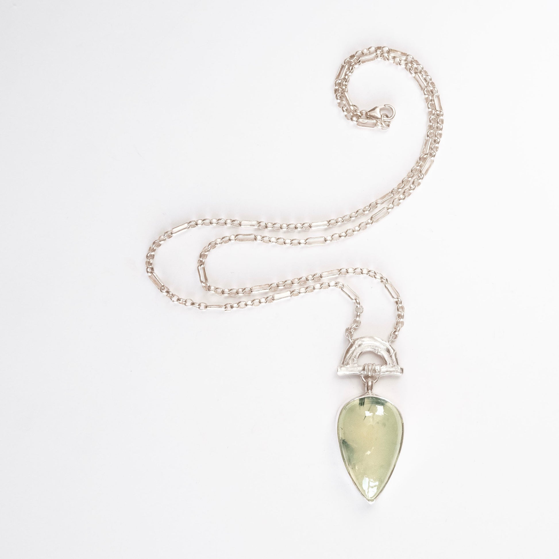 Pendant with  Pear-shaped pale green Prehnite Gemstone hanging from silver Bamboo Arch, on fine silver chain. white background