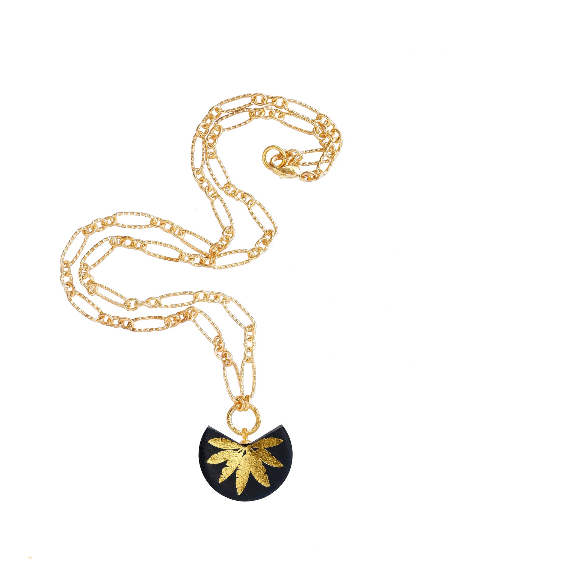 leather medallion pendant with gold palm tree print, on gold chain.