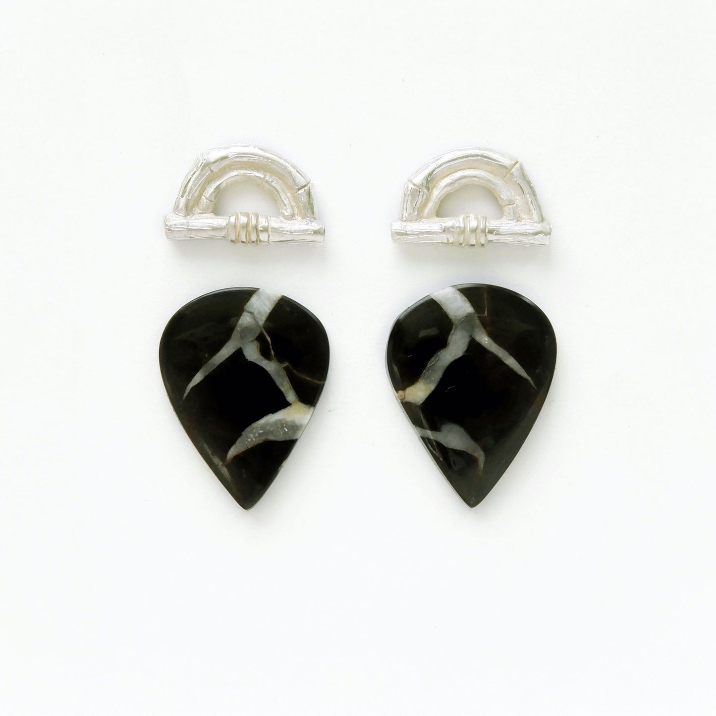 Sterling Silver bamboo sunrise arch design pieces (earring tops) with pointed pear shaped black Septarian gemstone cabochons , with white marbling.