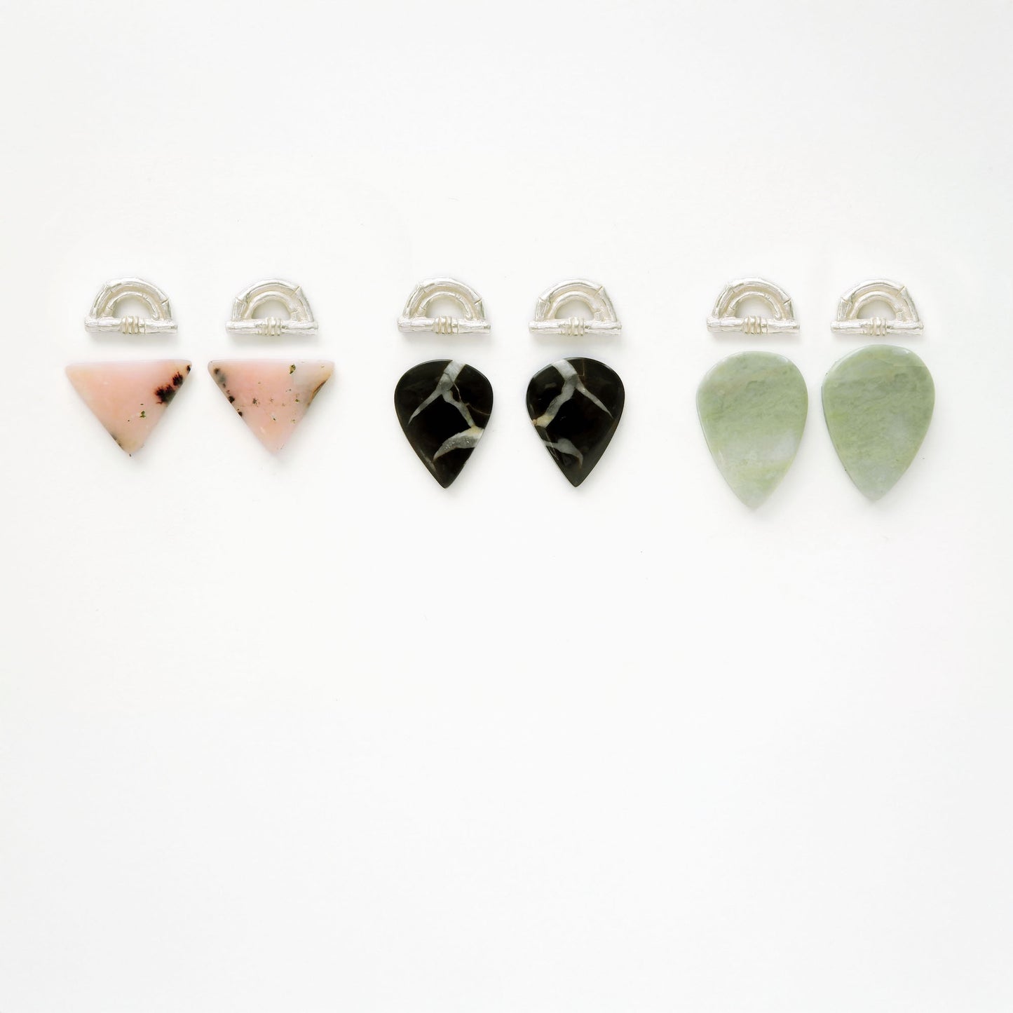 three pairs of Sterling Silver bamboo sunrise arch design pieces (earring tops) with pointed gemstone cabochons in pale pink opal, black marbled Septarian, and light green Serpentine.