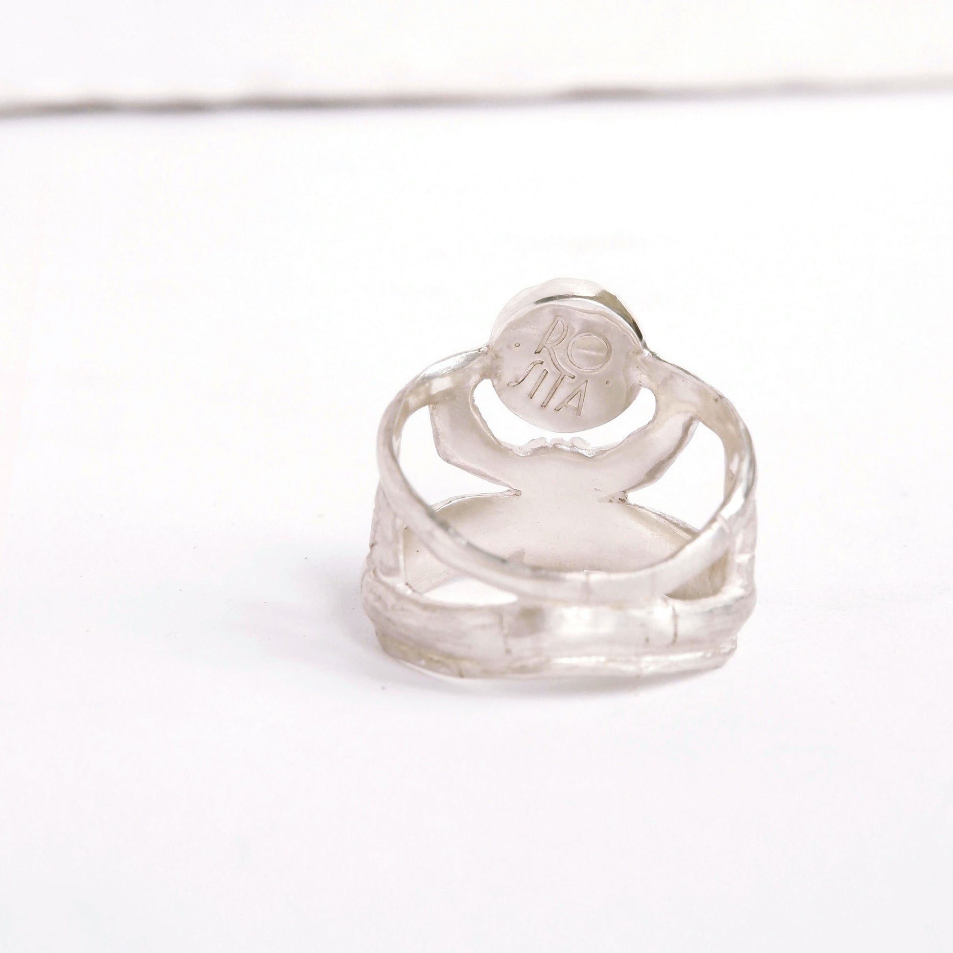 structural open-work ring in a bamboo style, featuring round central stone setting. Shown from the back/inside. Sterling Silver.