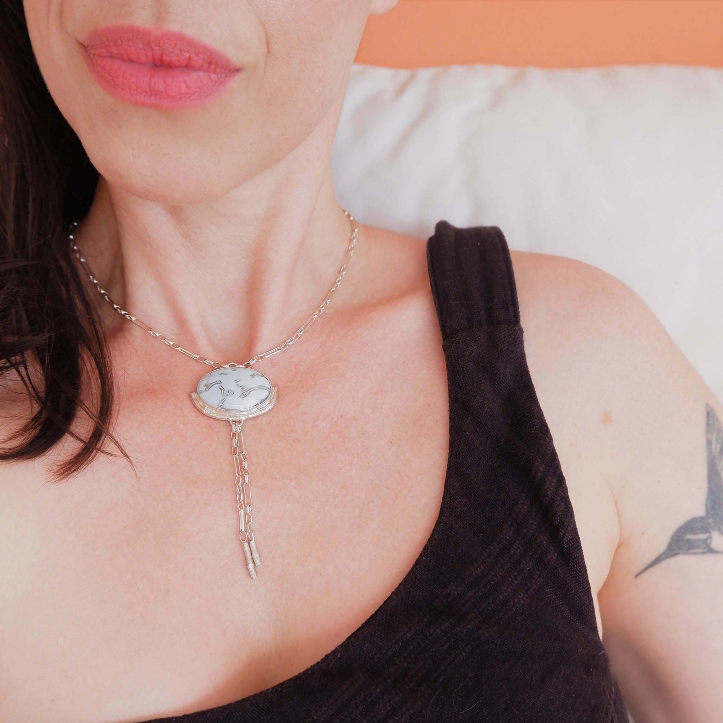 Silver Lariat style chain necklace, with a large marbled pale sky blue peruvian opal pendant, framed  by a hlaf halo of silver bamboo. On model.