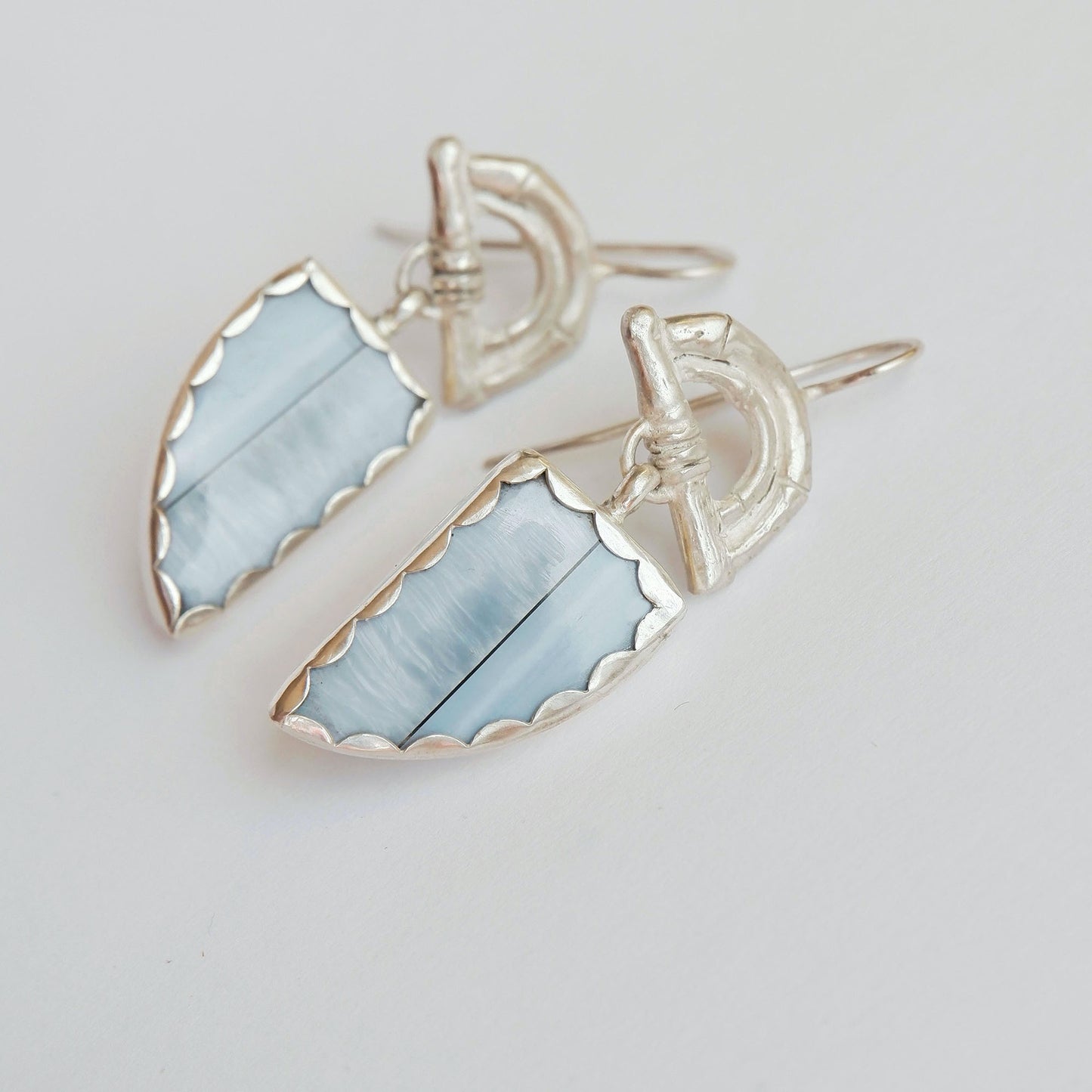 Sterling Silver hook earrings featuring bamboo sunrise arch design, with pointed gemstone drop pendants in light blue opal