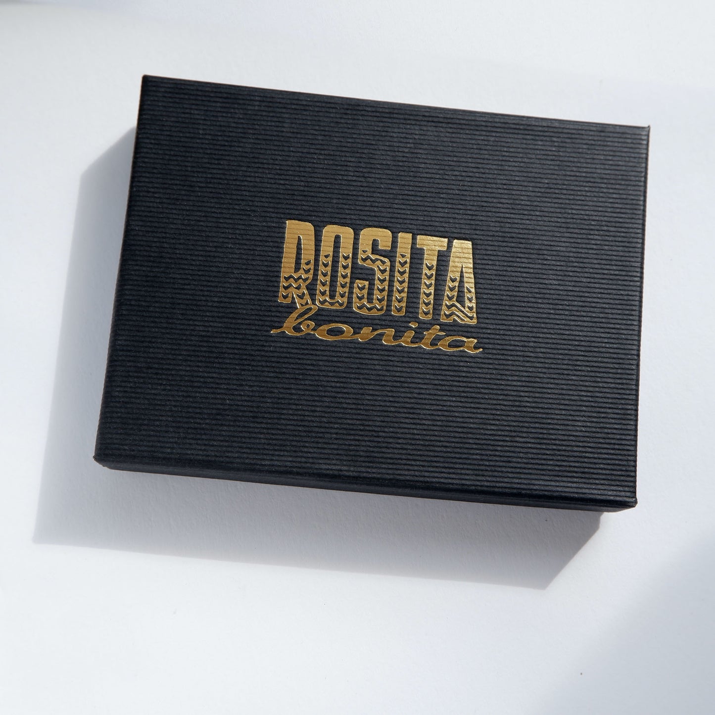 black ridged cardboard box with Rosita Bonita logo printed in gold