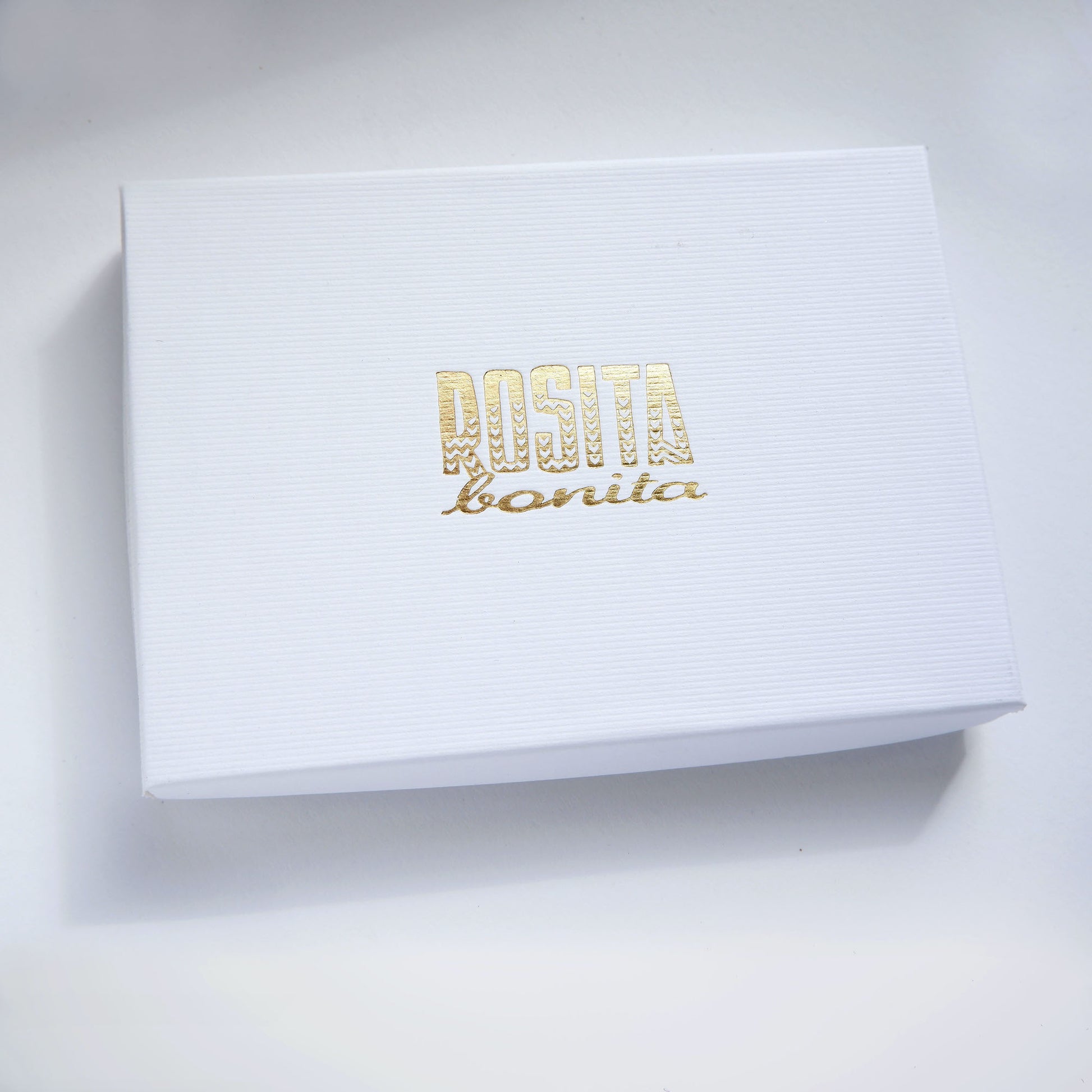 white ridged cardboard box with Rosita Bonita logo printed in gold