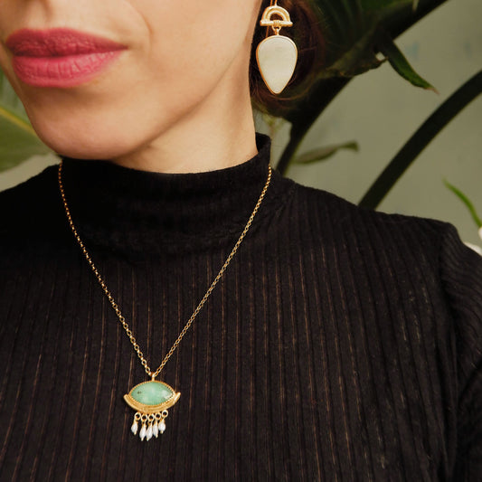 Green peruvian Opal "eye" pendant. Bamboo "hammock" style pendant, with faceted marquise cut gemstone, in gold vermeil, with a fringe of freshwater pearls, on gold chain. On model, wearing black.