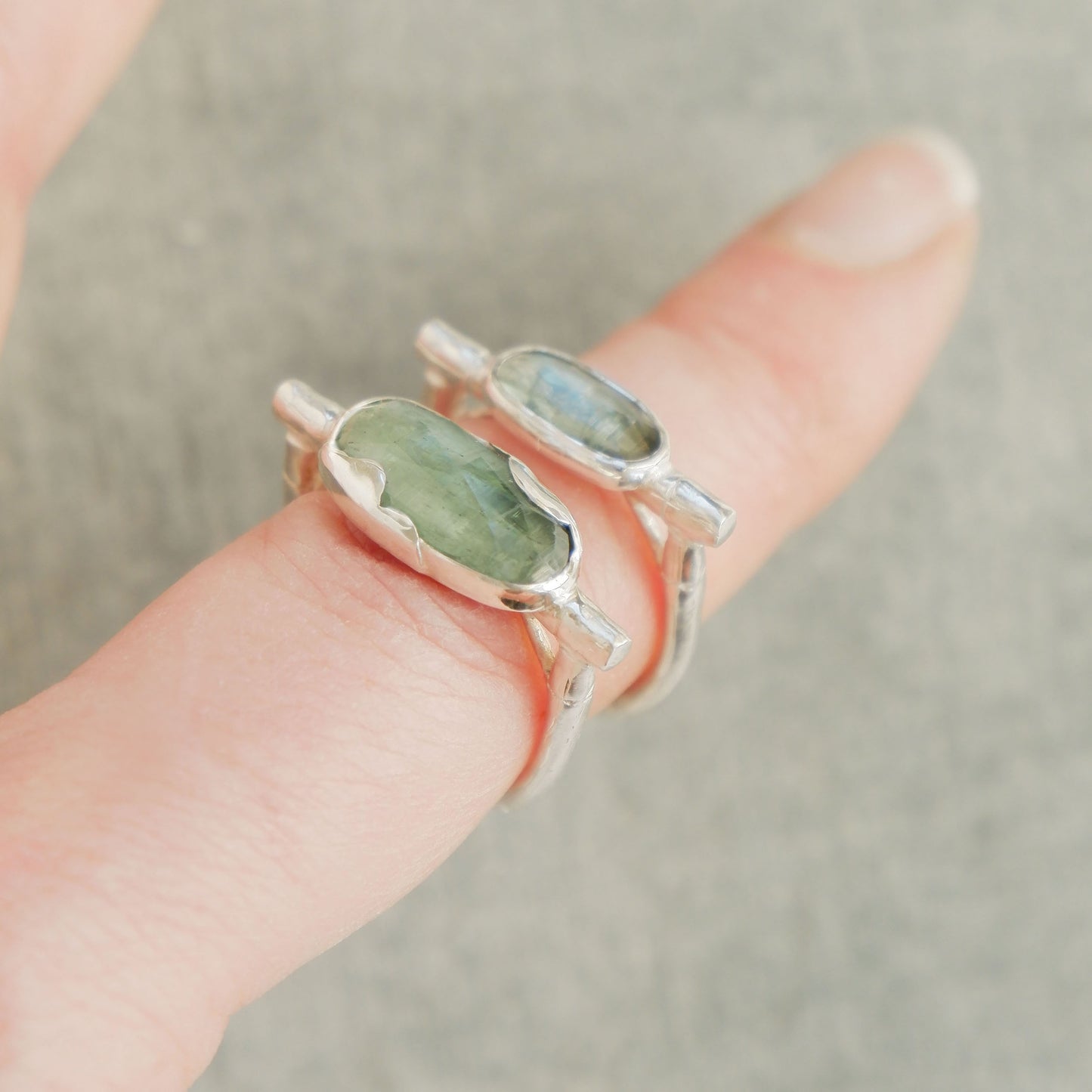 2 different sizes of sterling silver organic bamboo cane ring, set with pale mint green kyanite cabochon on finger