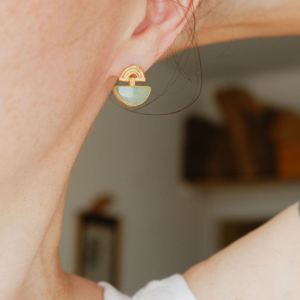 small stud earrings in sterling silverl, featuring triple arches of bamboo, hung with a half moon shaped Aventurine gemstone, set with silver teeth, on model