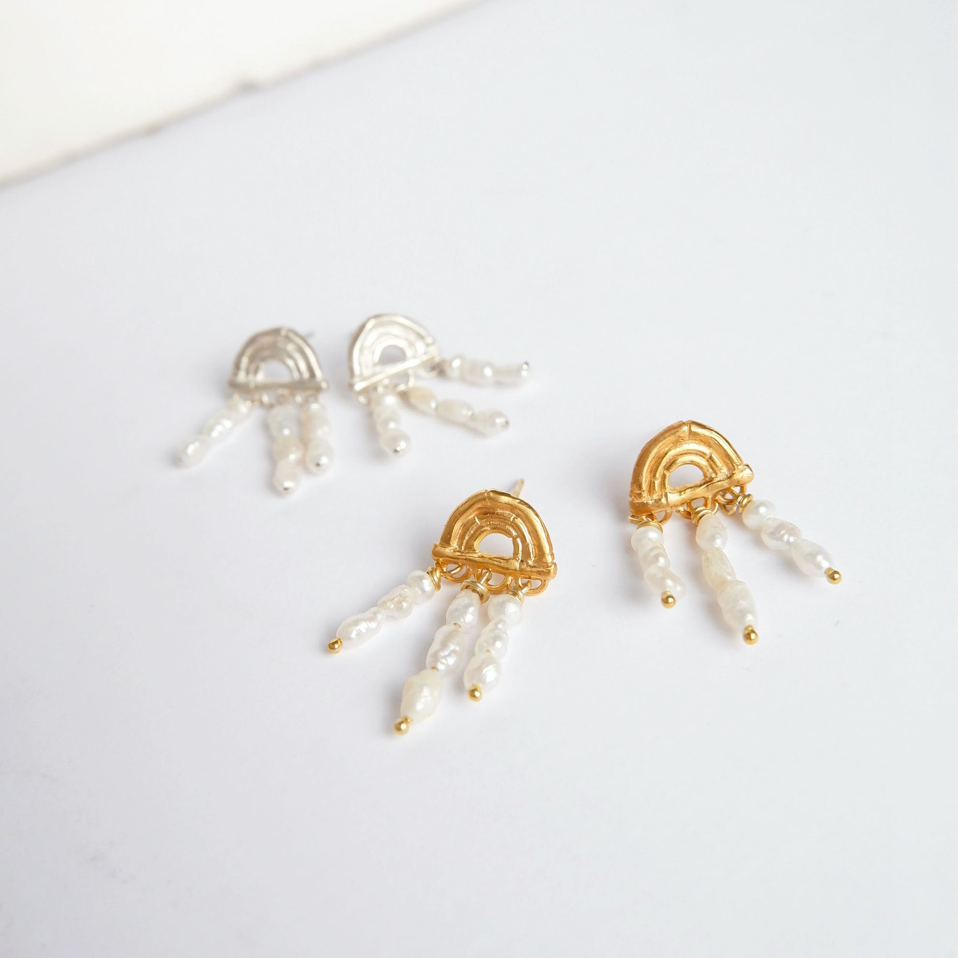 small stud earrings in Gold Vermeil and sterling silver, featuring triple arches of bamboo, hand hung with short strings of freshwater pearls. Shown on a white background.