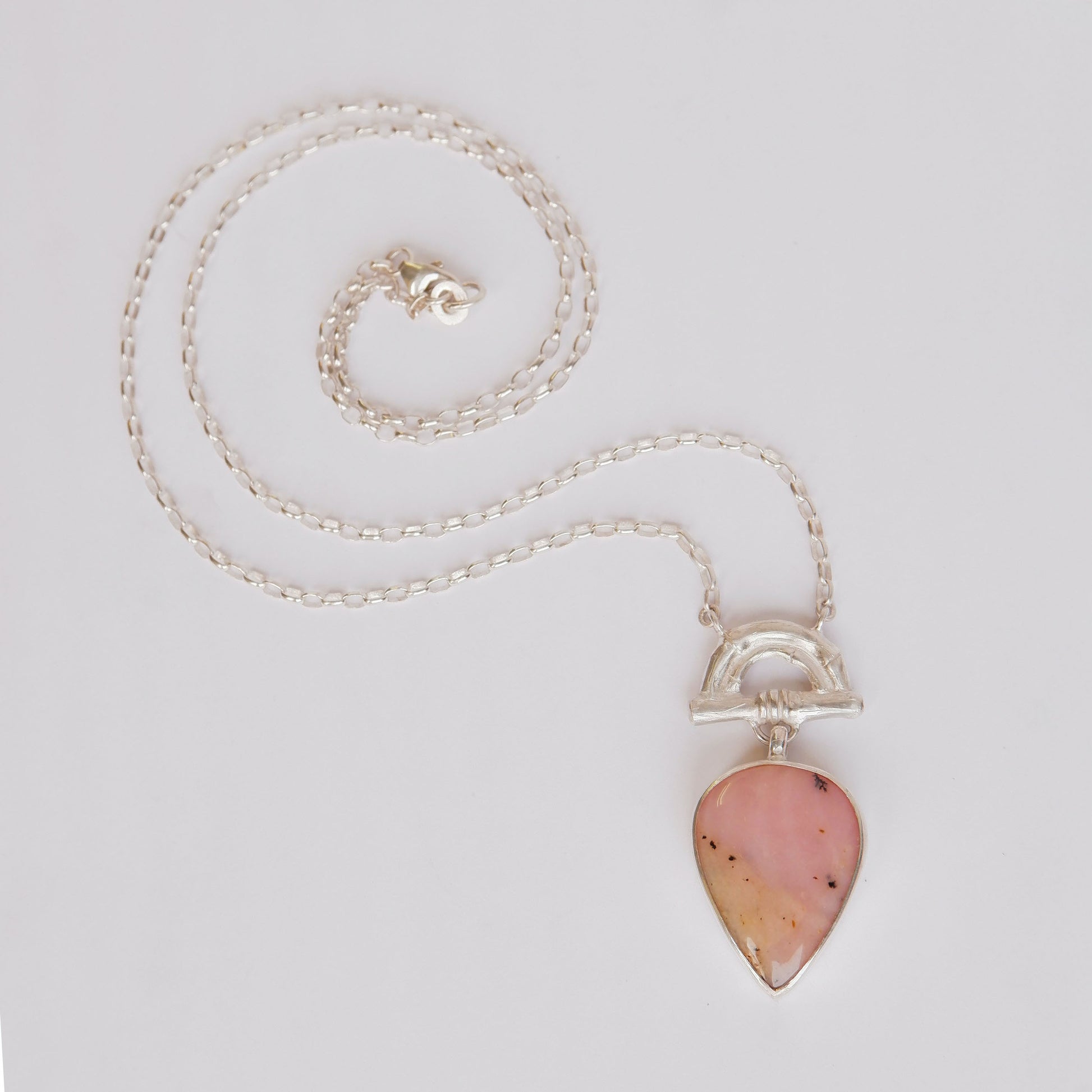 Pendant with Pear-shaped Pink Opal Gemstone hanging from silver Bamboo Arch, on fine silver chain.