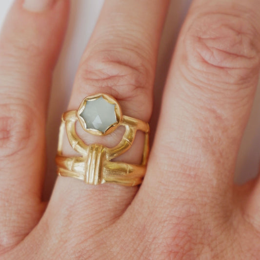 structural open-work ring in a bamboo style, featuring round blue/green cabochon aquamarine gemstone in a scalloped setting. Gold Vermeil. Shown on a hand for scale