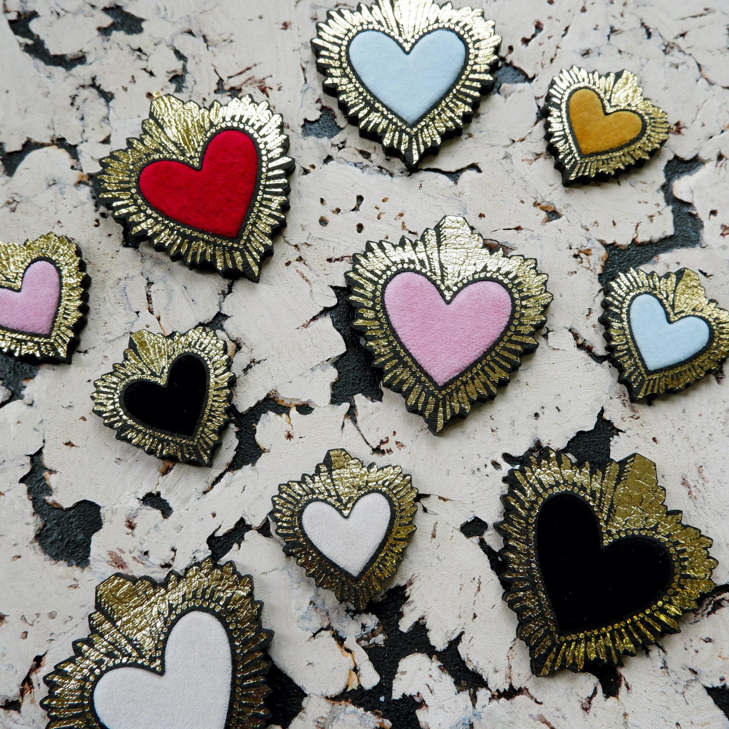 selection of velvet sacred heart pendants, with gold starburst frames, in a range of colours