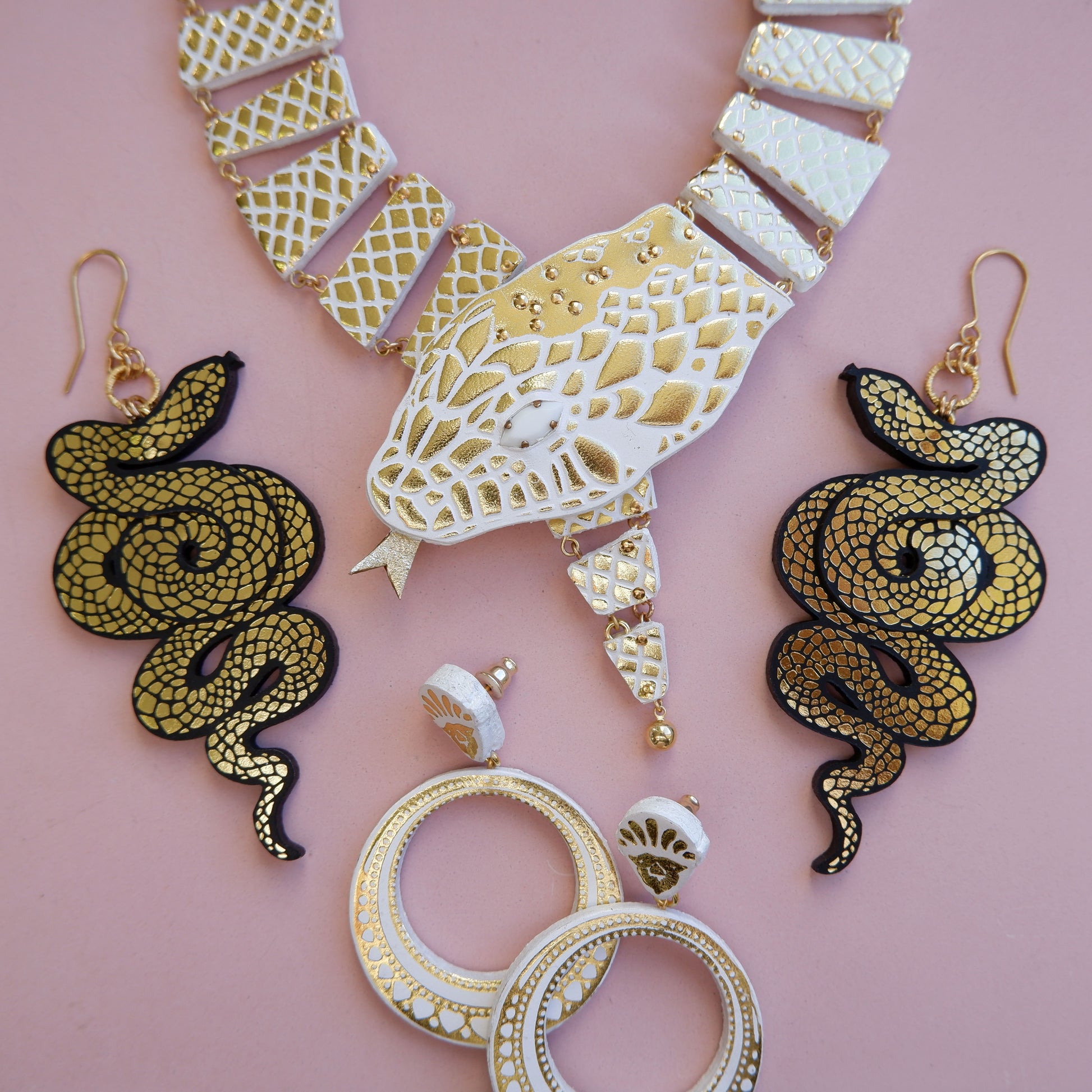 white & gold serpent necklace with black & gold serpent earrings