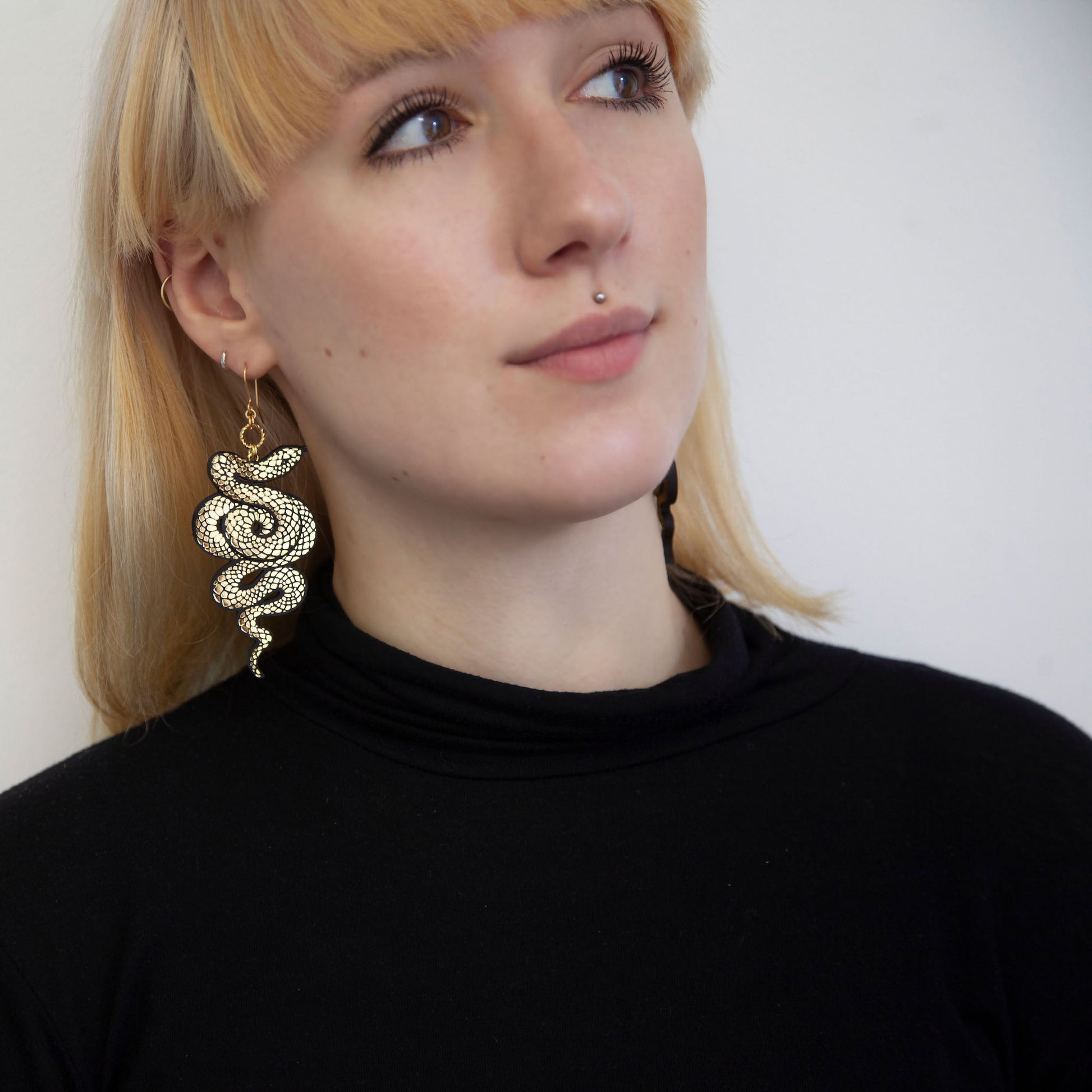 blonde model with black and gold snake earring