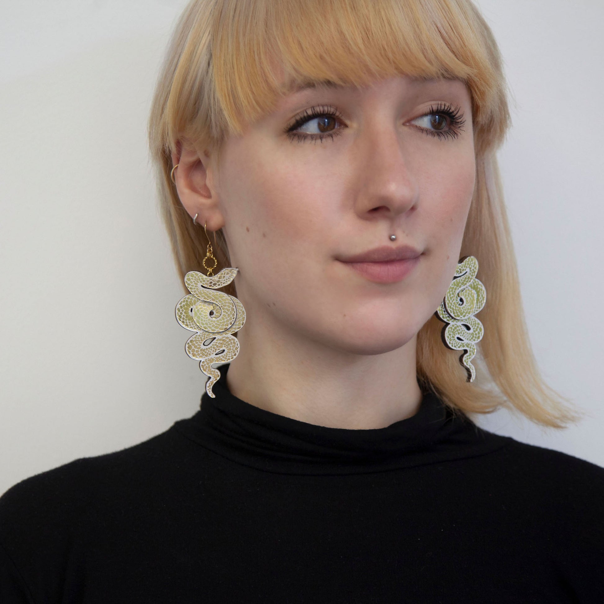 blonde model with whte & gold snake earrings
