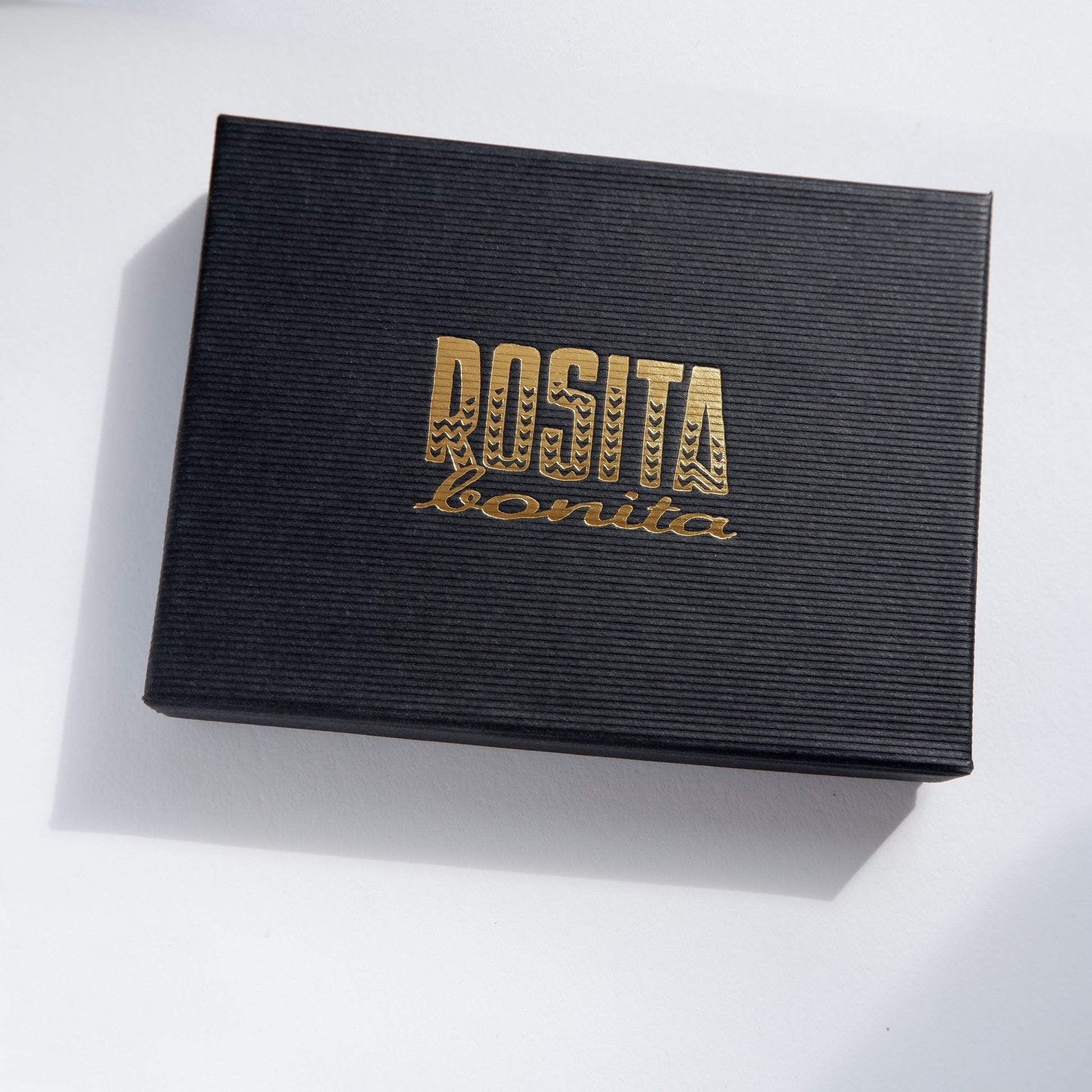 black pinstripe cardboard jewellery box, with rosita bonita logo in gold
