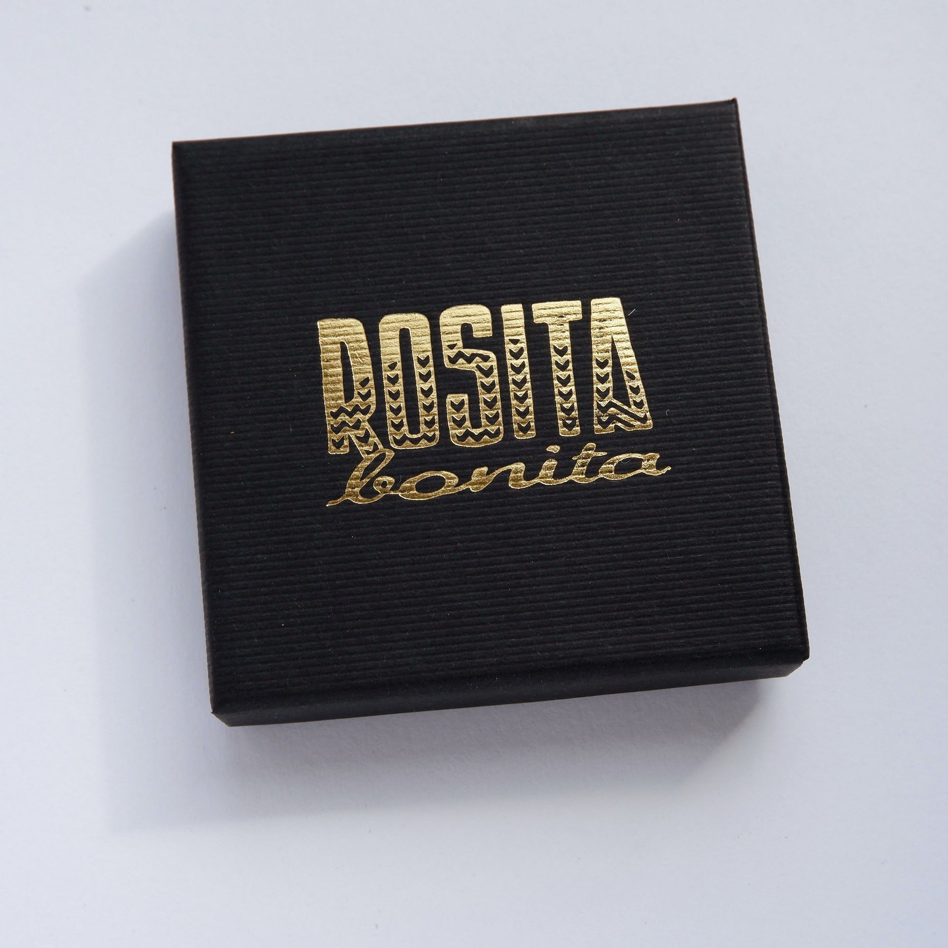 Black pinstripe cardboard jewellery box with rosita bonita logo in gold