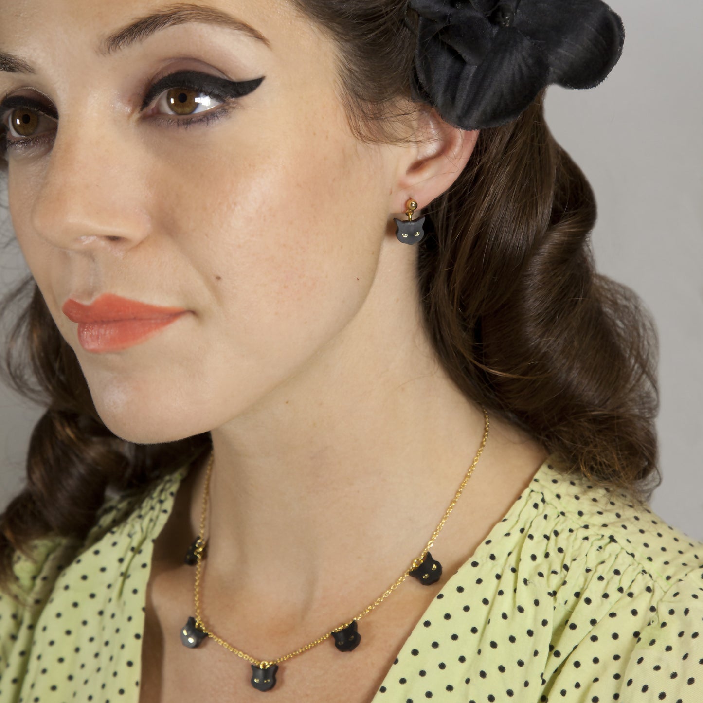 model wearing black leather cat face charm necklace & matching drop stud earrings.