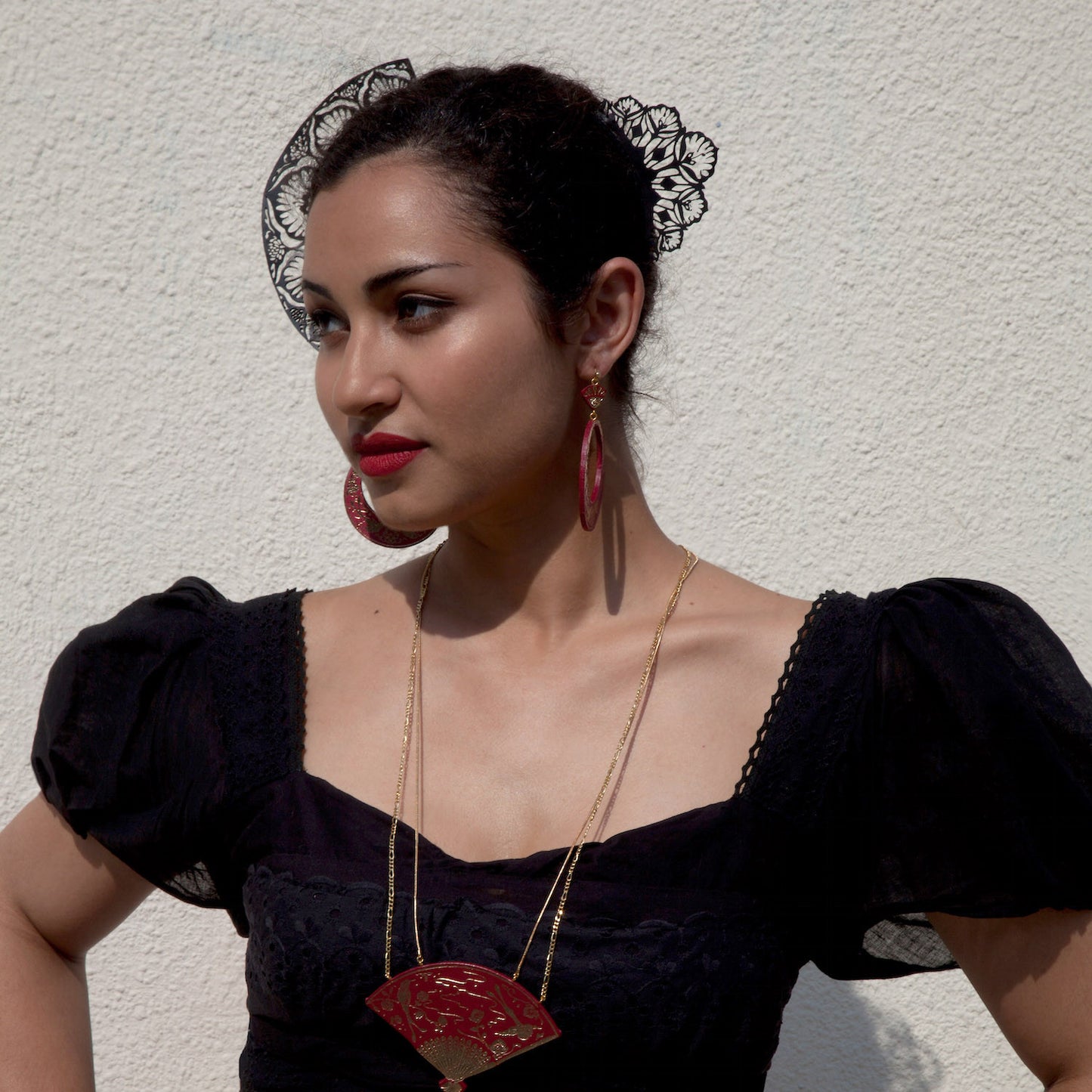 model wearing black laser-cut lace style leather hair combs & ox blood red leather jewellery
